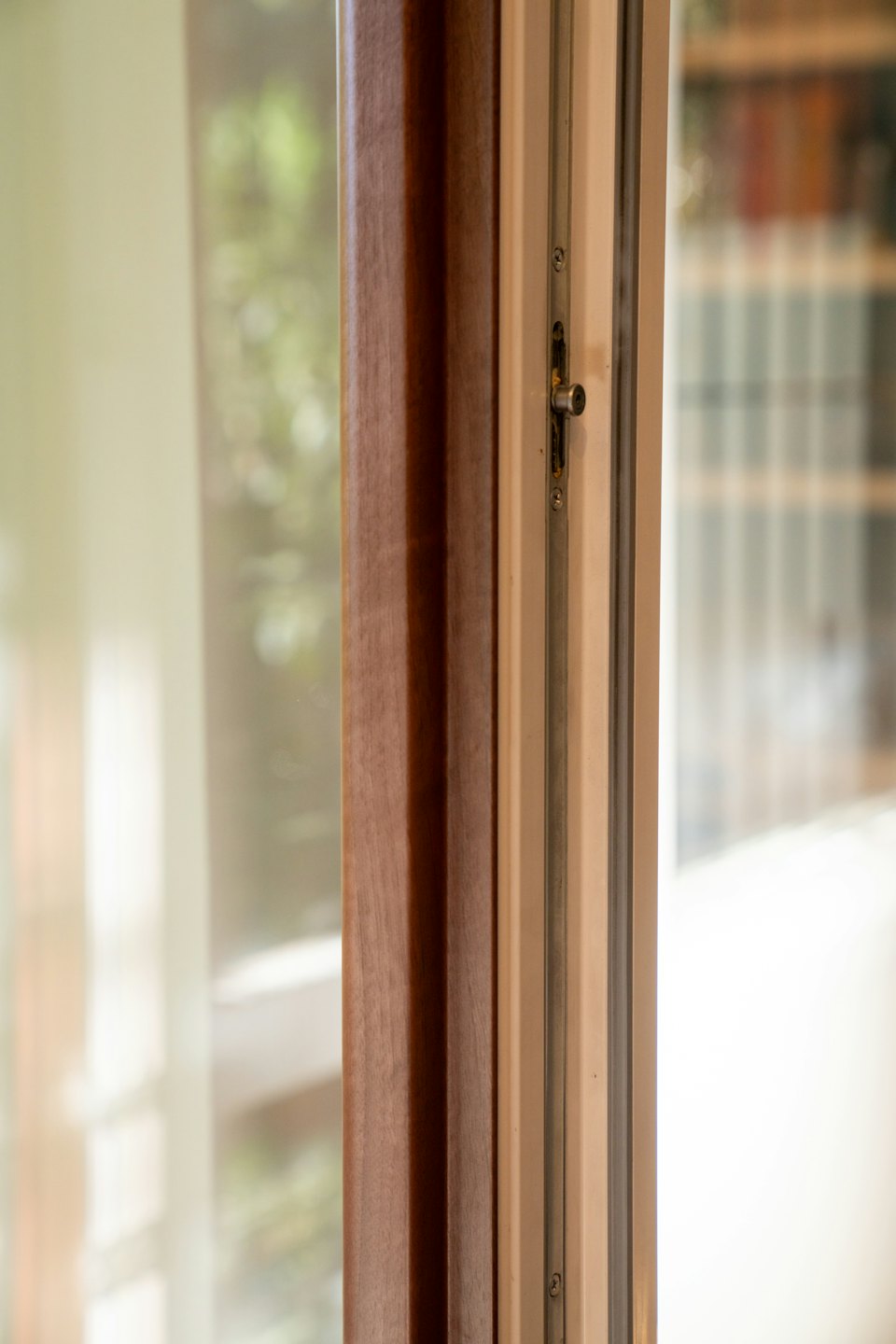 Moderna cornice di finestra con finiture in legno e meccanismo di blocco.